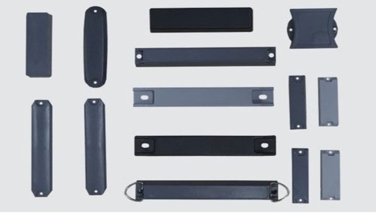 A collection of various Ferric Series RFID tags in different shapes and sizes, featuring durable black and grey hard shells designed for mounting on metal surfaces via screws, rivets, or adhesive.